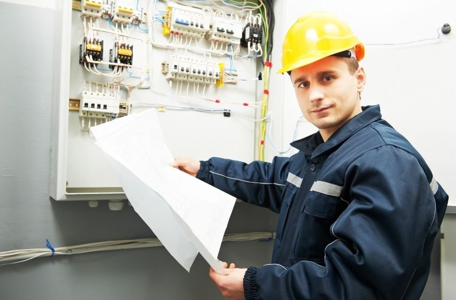 Engenheiro eletricista analisando projeto diante do quadro